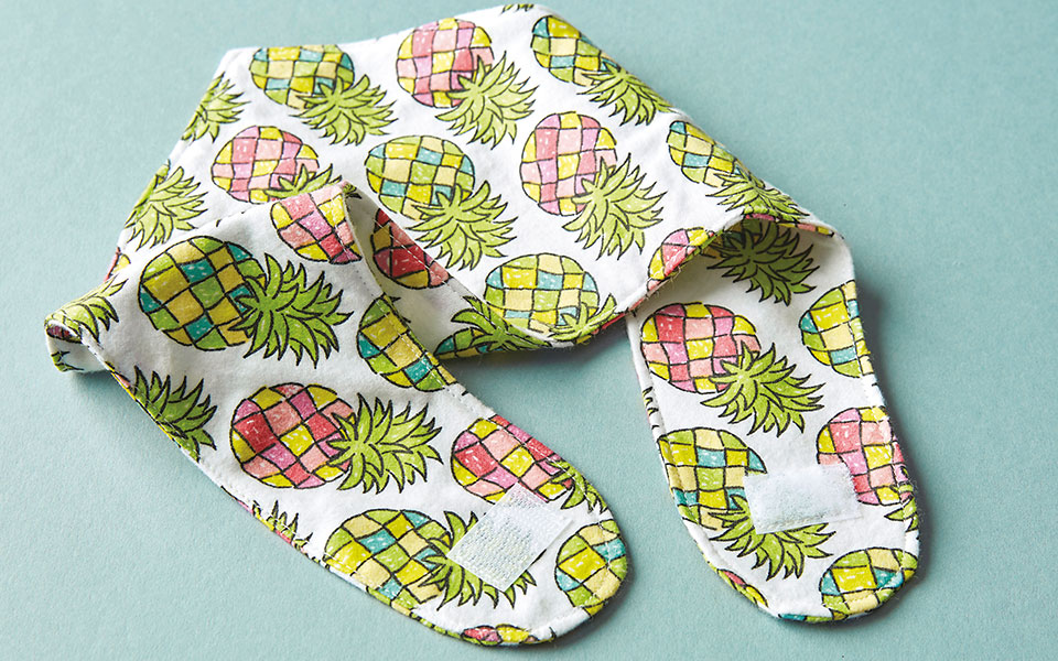 a bib with pineapple fabric with velcro on the ends