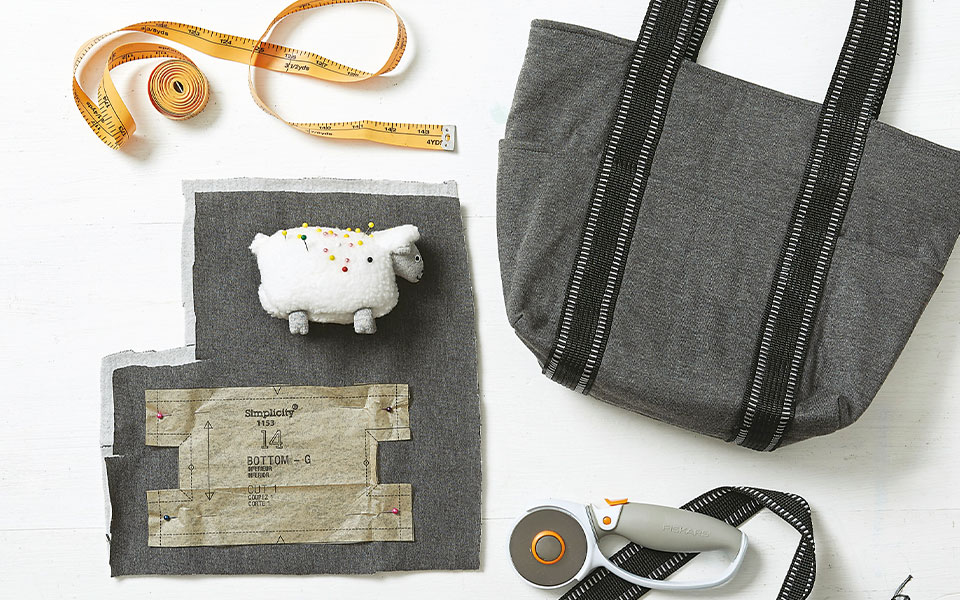 sewing supplies beside a black and gray bag