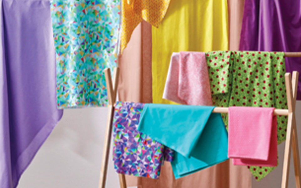 assortment of fabric hanging up on a wood drying rack