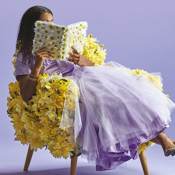woman in a purple dress reading in a yellow chair