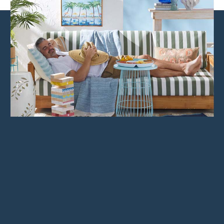 man laying on a couch with summer decor