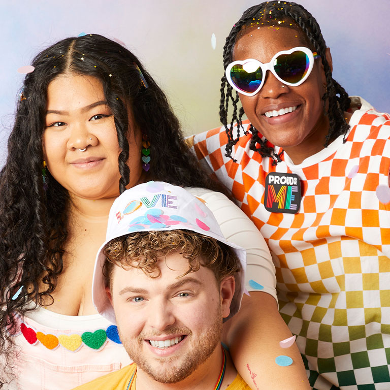 Three people wearing rainbow pride clothing