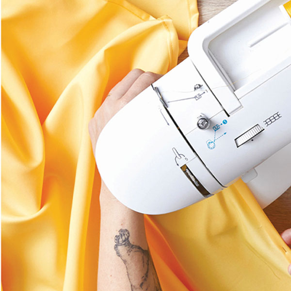 sewing machine sewing yellow organza fabraic